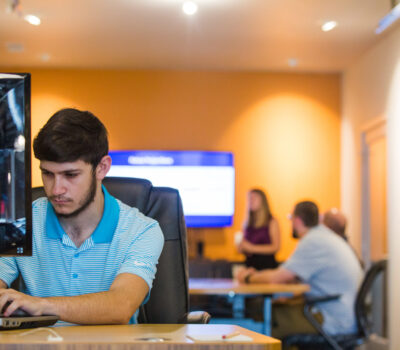 Man in blue polo works on computer