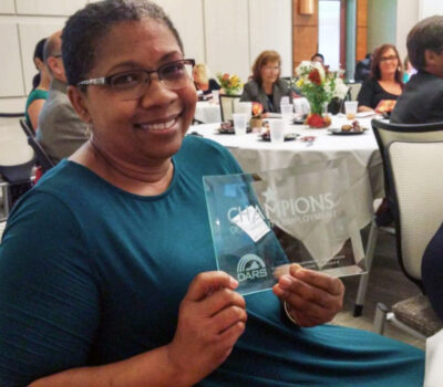Community Recovery Program’s Program Manager Lisa Smith with the Champions award for community collaboration.